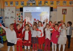 Dzieci z grupy III pozują do wspólnego zdjęcia machając biało-czerwonymi wstążkami. Ujęcie 3